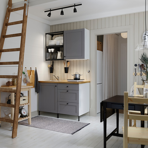 Cocina moderna con lámparas SKURUP grises sobre el mostrador, escalera de madera y comedor.