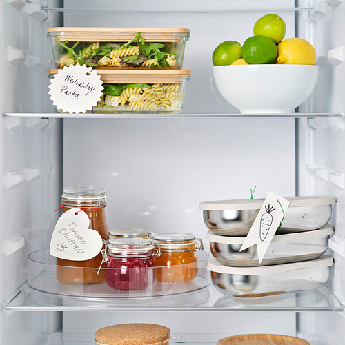 Abra el refrigerador con recipientes, frascos y frutas etiquetados. Las etiquetas ayudan a identificar el contenido.