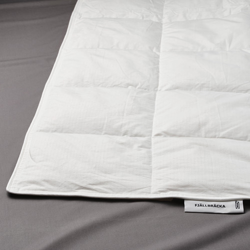 Edredón FJÄLLBRÄCKA de Ikea, de un blanco impoluto, cuidadosamente doblado, con tejidos y costuras de calidad, con una etiqueta con el nombre de la marca.