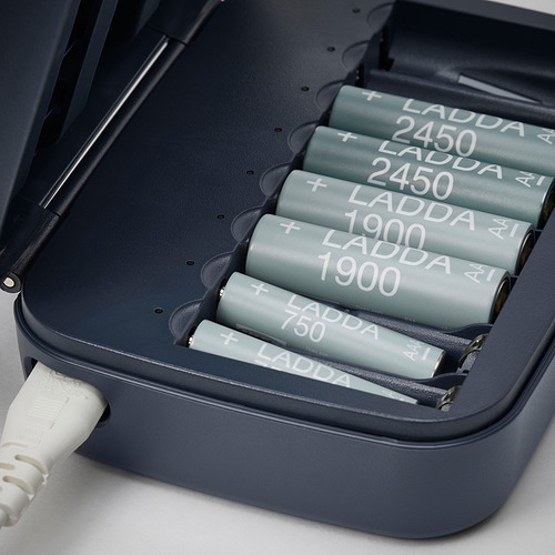 Cargador de batería negro con múltiples ranuras, carga de baterías recargables ladda, conectado a un cable de alimentación blanco.