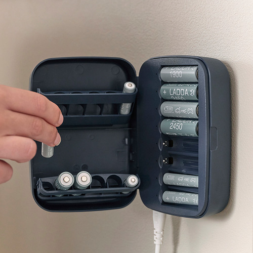Persona colocando la batería en el cargador LITOSFÄR con múltiples ranuras e indicadores led.