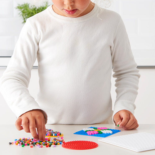 Manualidades infantiles de cuentas en tableros perforados, mejorando las habilidades motoras.