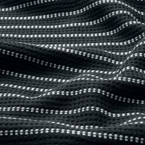 Toalla negra con patrón de gofre de puntos blancos, que muestra textura y artesanía.