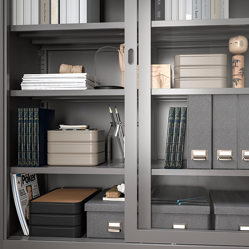 Estantes abiertos con cajas organizadas, libros y decoración. Las cajas tienen compartimentos fijos para pequeños artículos de escritorio.