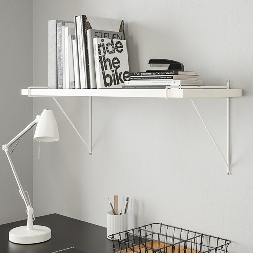 Estantería blanca BERGSHULT con libros y lámpara.