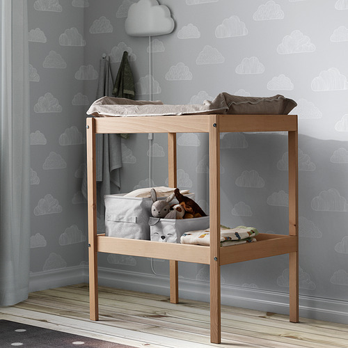 DRÖMSLOTT: pequeño cambiador de madera con cambiador, mantas y peluches. La pared tiene patrones de nubes. Gris claro, compacto.