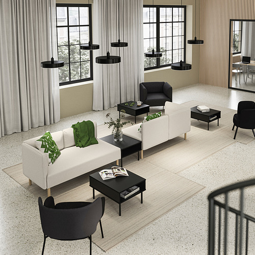 Well-arranged modern living space with white LILLEHEM sofas, black tunsta tables, and hanging lamps. Large windows with curtains.