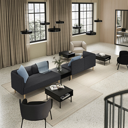 Sala de estar moderna con sofá LILLEHEM en gris, mesas de centro negras, cortinas beige y lámparas colgantes negras.