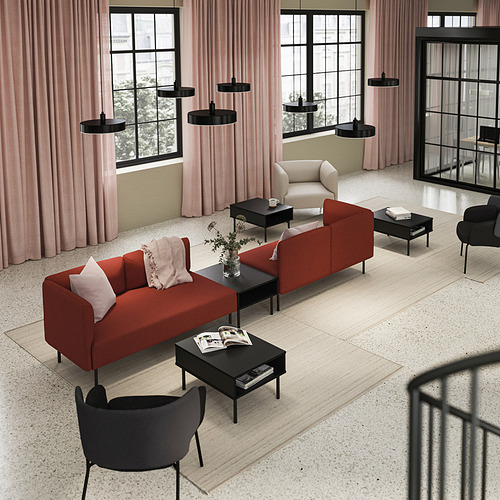 Moderno salón con sofá naranja LILLEHEM, sillones negros, lámparas colgantes circulares y grandes ventanales con cortinas rosas.