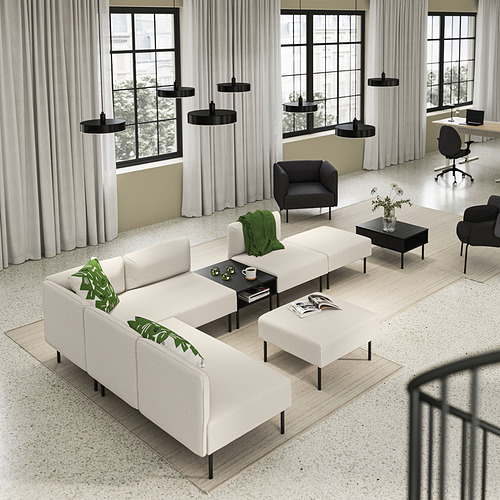 Sala de estar moderna y minimalista con sofá LILLEHEM blanco, detalles en negro, suelo de madera, grandes ventanales y lámparas colgantes.