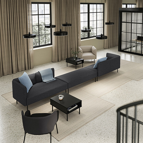 Sala de estar moderna con grandes ventanales, sofá LILLEHEM, mesa de centro negra y luces.