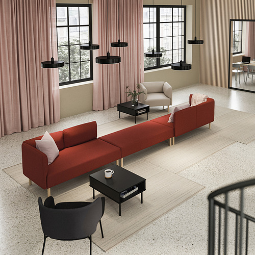 Salón minimalista con sofá rojo, mesas/sillas negras, cortinas rosas, lámparas negras.