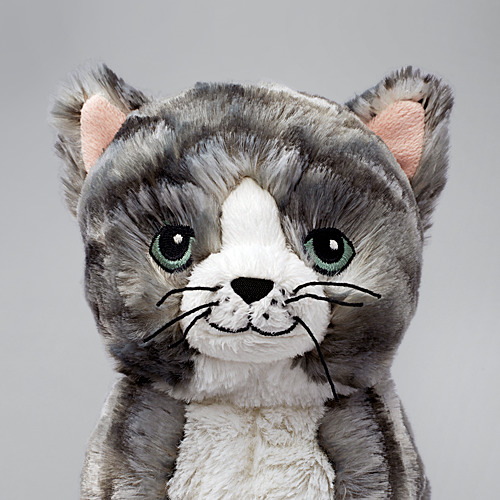 Peluche de gatito gris suave, ojos grandes, cara amistosa, hecho de poliéster.