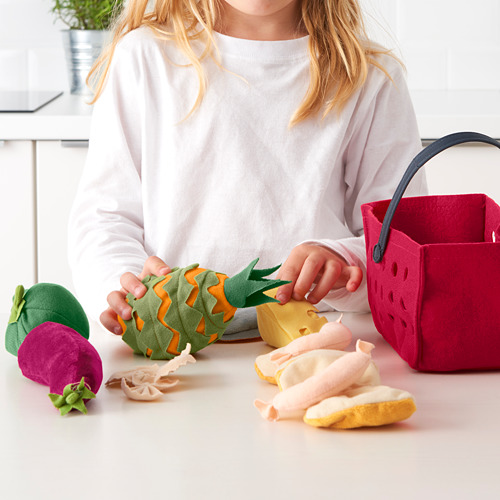 Niño jugando con comida de juguete LÅTSAS, cortando piña en la mesa.