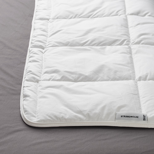 Edredón nórdico blanco ultrasuave sobre ropa de cama gris, de la marca STRANDMOLKE, que muestra lujo y calidad.