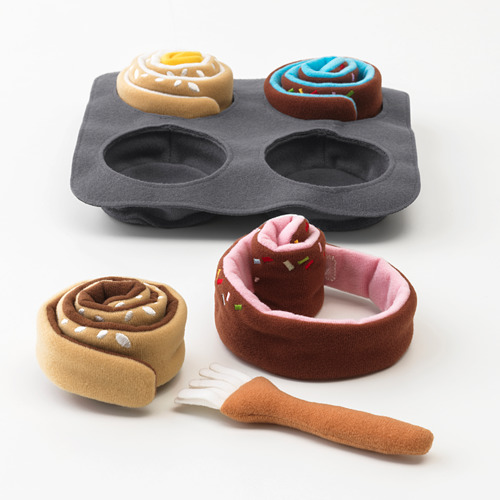 Un juego de juguete para hornear con una bandeja y bollos de peluche. Los bollos están diseñados para ser enrollados y cepillados, lo que promueve el juego de simulación y las habilidades motoras finas.