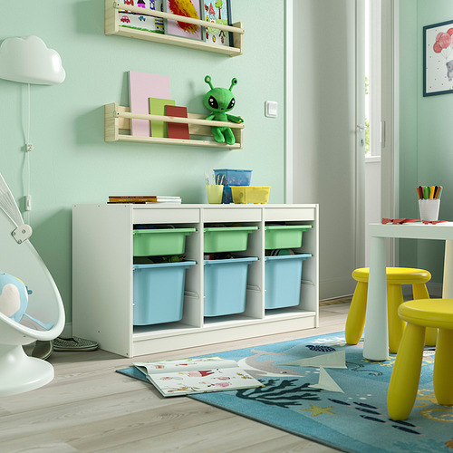 Sala de juegos para niños con almacenamiento TROFAST blanco, paredes verdes y alfombra. Alienígena de juguete, cajas de plástico y taburetes.