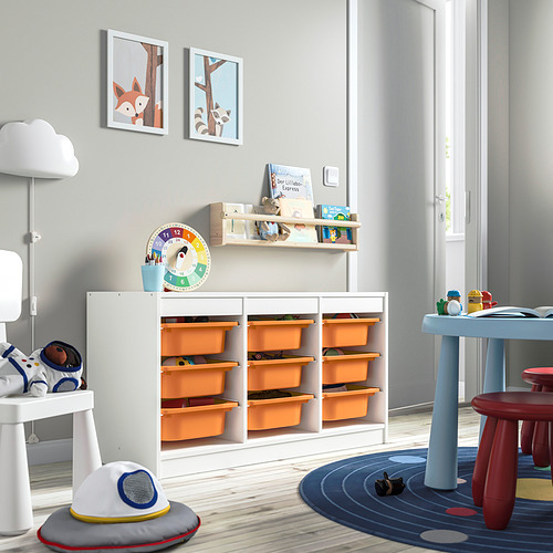 Habitación infantil con mueble de almacenaje TROFAST con cajas de plástico naranja y marco blanco. La unidad grande y baja tiene capacidad para juguetes, libros y tiene una decoración divertida.
