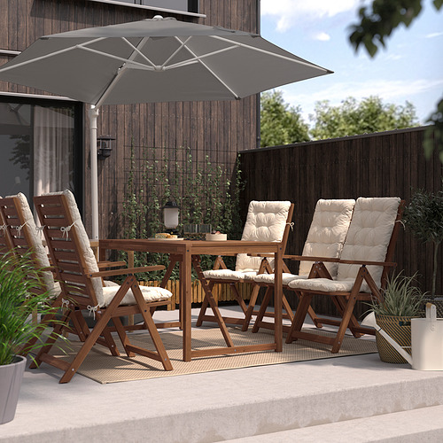 Montaje del patio con sombrilla gris HÖGÖN, mesa de madera y cuatro sillas con cojines beige.