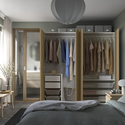 Dormitorio con armario abierto que exhibe ropa, estantes y cajones organizadores. Iluminación tenue en el interior.