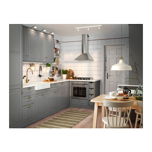 Cocina moderna de color gris con suelo de madera, mesa blanca y lámparas colgantes. Tiene un fregadero HAVSEN y una estufa tradicional.