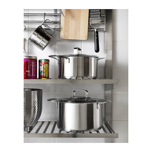 Sistema de estanterías KUNGSFORS de acero inoxidable para ollas y sartenes en una cocina moderna.