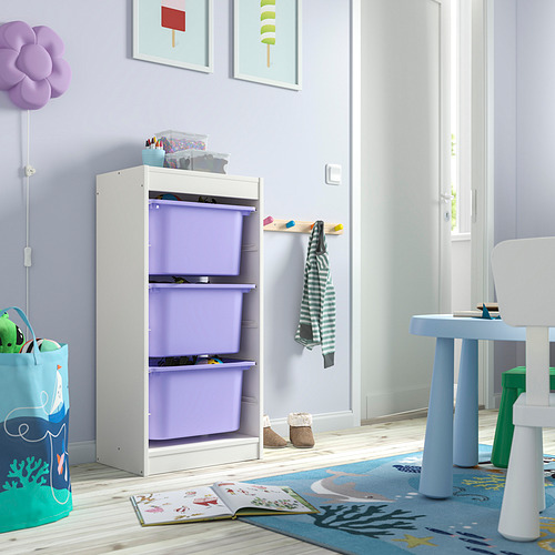 Habitación para niños con unidad de almacenamiento TROFAST blanca, contenedores morados y mesa de juguetes. Decoración colorida, alfombra y juguetes.