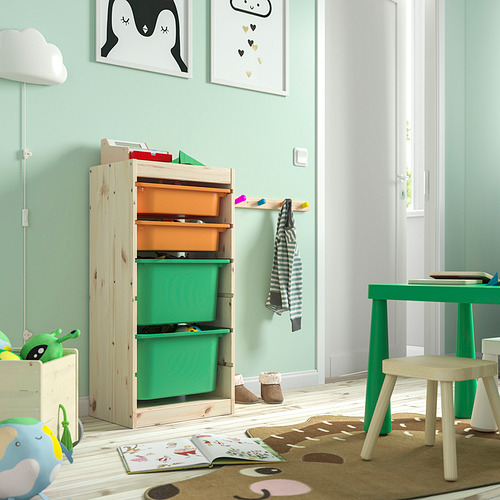Habitación para niños con almacenamiento TROFAST, cajas de colores, marco de madera. Muebles luminosos, decoración lúdica, puerta abierta y libros en el suelo.