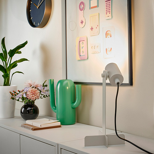 Escritorio moderno con lámpara FLOTTILJ, decoración de cactus y flores.