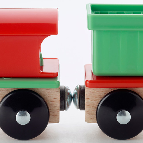 Dos vibrantes vagones de tren de juguete, rojo y verde, con robustas ruedas negras, conectados entre sí.