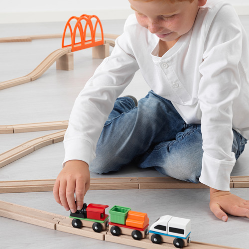 Los niños juegan con la vía del tren LILLABO y los coloridos vagones.