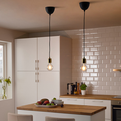 Cocina moderna con luces SKAFTET sobre una isla llena de frutas.
