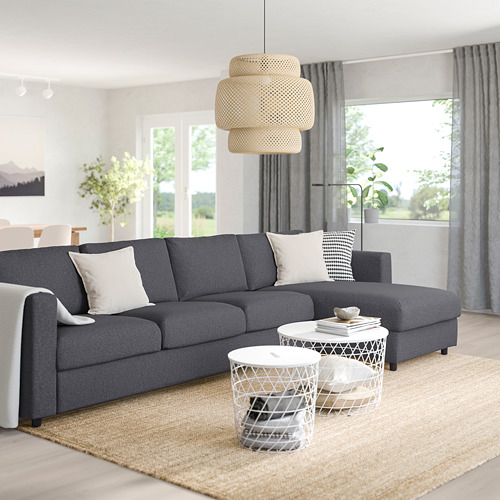Moderno living comedor con seccional VIMLE, mesas blancas, alfombra, plantas, y grandes ventanales con cortinas.