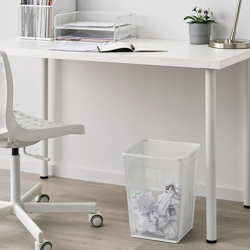 Papelera de malla metálica blanca debajo del escritorio junto a la silla. Diseño sencillo y moderno. Más pequeño que la silla y el escritorio.