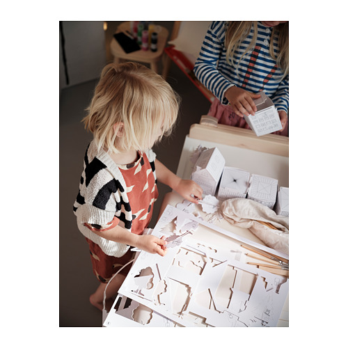 Dos niños haciendo manualidades con plantillas de cartón blanco MÅLA, construyendo casas y estructuras, potenciando la creatividad y la motricidad fina.