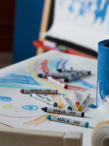 Zona de arte infantil con lápices de colores MÅLA en papel, vaso azul cerca.