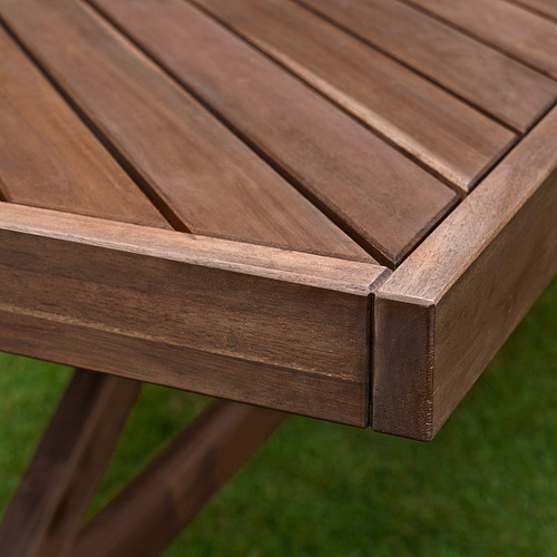 Mesa de exterior de madera oscura con acabado liso y patrón de listones en espiga.