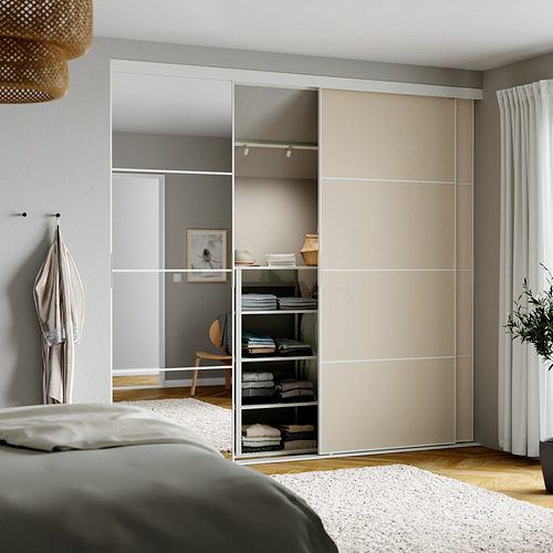 Dormitorio con armario SKYTTA, beige y cristal, colgante claro, cojín de cama gris.