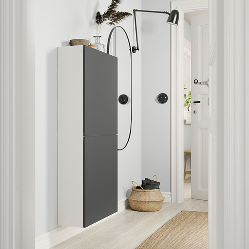 Modern white and grey wall cabinet with black accents, featuring a sleek design and storage basket, mounted on a pristine wall.