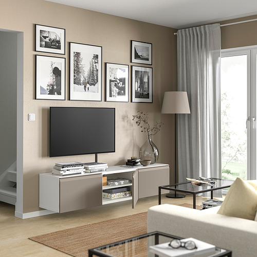 Sala de estar moderna con banco de televisión BESTÅ de color claro, TV de pantalla plana, cortinas grises y fotos enmarcadas en blanco y negro en la pared.