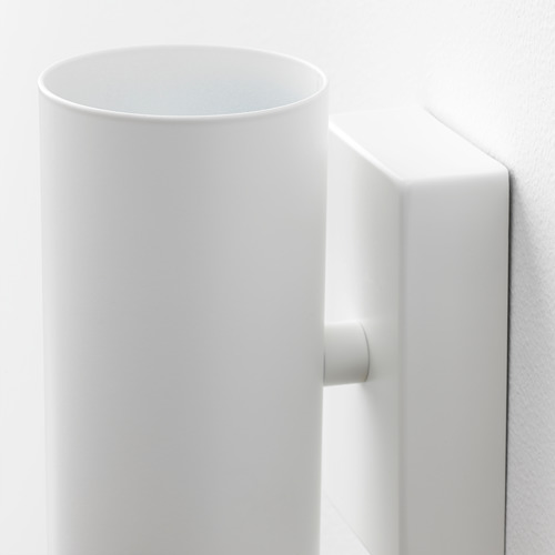Moderna lámpara de pared blanca con pantalla redondeada y base robusta, que emite luz hacia abajo.