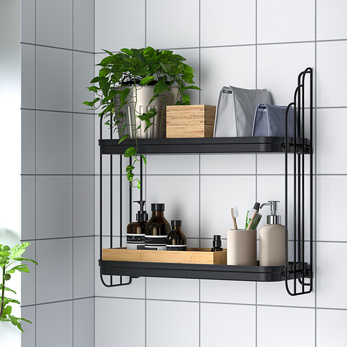 Wall-mounted shelf with two tiers storing bathroom items: bottles, toothbrushes, towels, and a plant in a tiled room.