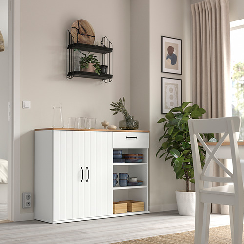 Sala de estar moderna con aparador blanco SKRUVBY, planta en maceta y estantes de pared. Diseño limpio y minimalista.
