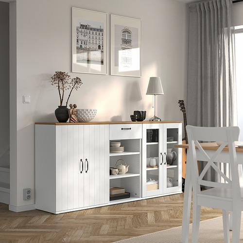 Moderno aparador blanco en el comedor con decoración, guitarra, planta y cuadros enmarcados.