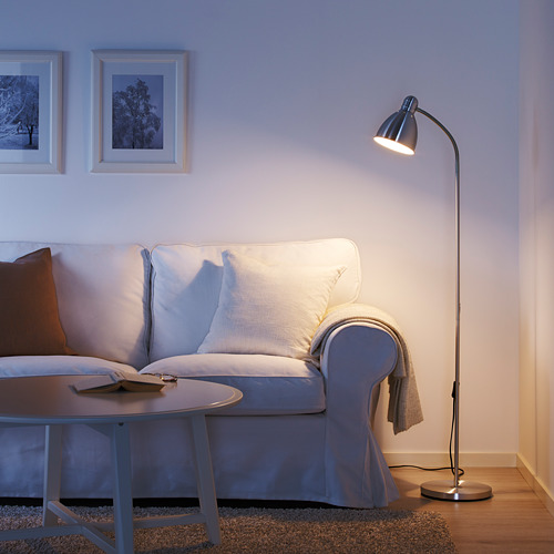 Sala de estar con lámpara LERSTA, sofá, fotos y mesa de centro.