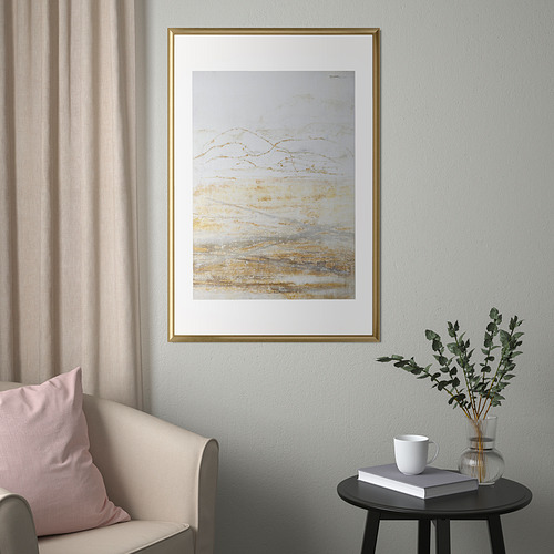 Decoración moderna de la sala de estar: marcos SILVERHÖJDEN, silla de cortina gris, mesa auxiliar con libro, taza y eucalipto.