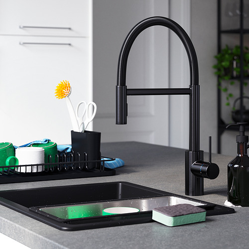 Cocina moderna con grifo negro SALLSJÖN , rociador abatible, fregadero negro, artículos de limpieza y gabinetes blancos.