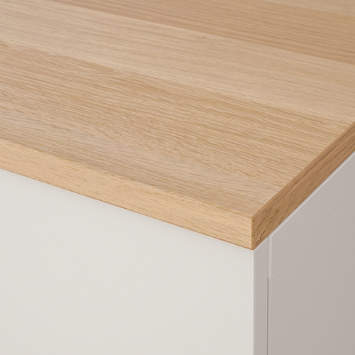 Primer plano de un tablero moderno de madera clara con bordes lisos y redondeados, que muestra su grano fino y su acabado de calidad.