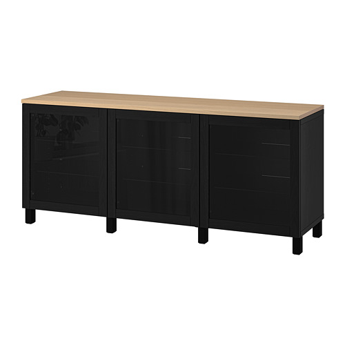 Exhibe una unidad de almacenamiento de madera negra y clara, con tres secciones: dos con puertas de vidrio y una con puertas sólidas, diseñadas para uso doméstico.