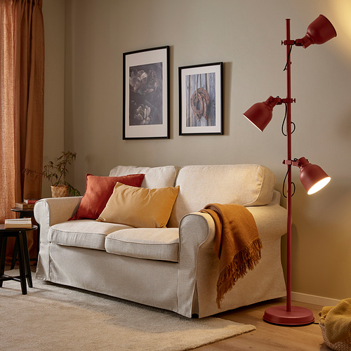 Sala de estar con sofá crema, detalles en naranja y lámpara HEKTAR roja de estilo industrial.